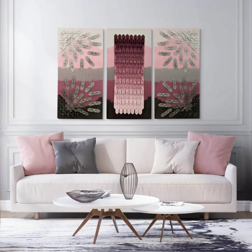 Contemporary visual art over a couch with pink and gray pillows and a coffee table in front of a white wall