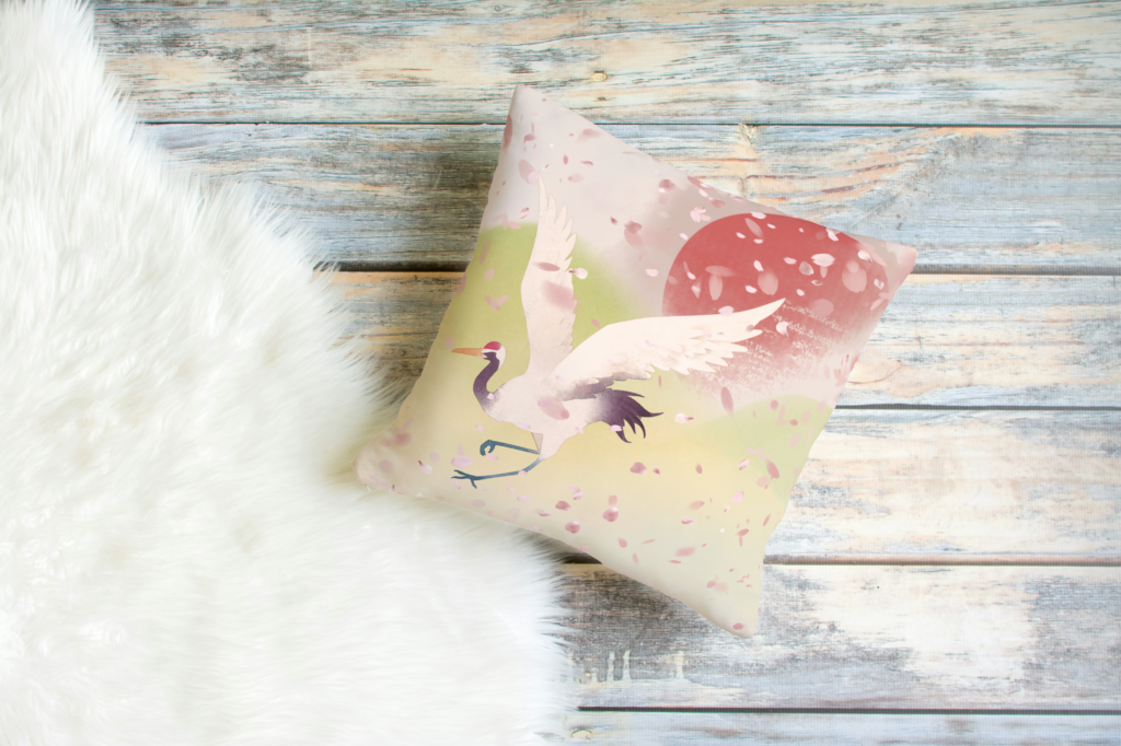 Red crowned crane flying in a field of cherry blossom petals.